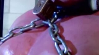 Submissive man struggles while in chains & dominated