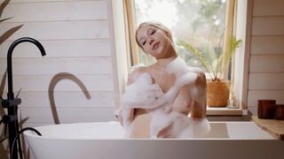 Petite blonde teen gets naked in the bathtub to reveal soapy tits